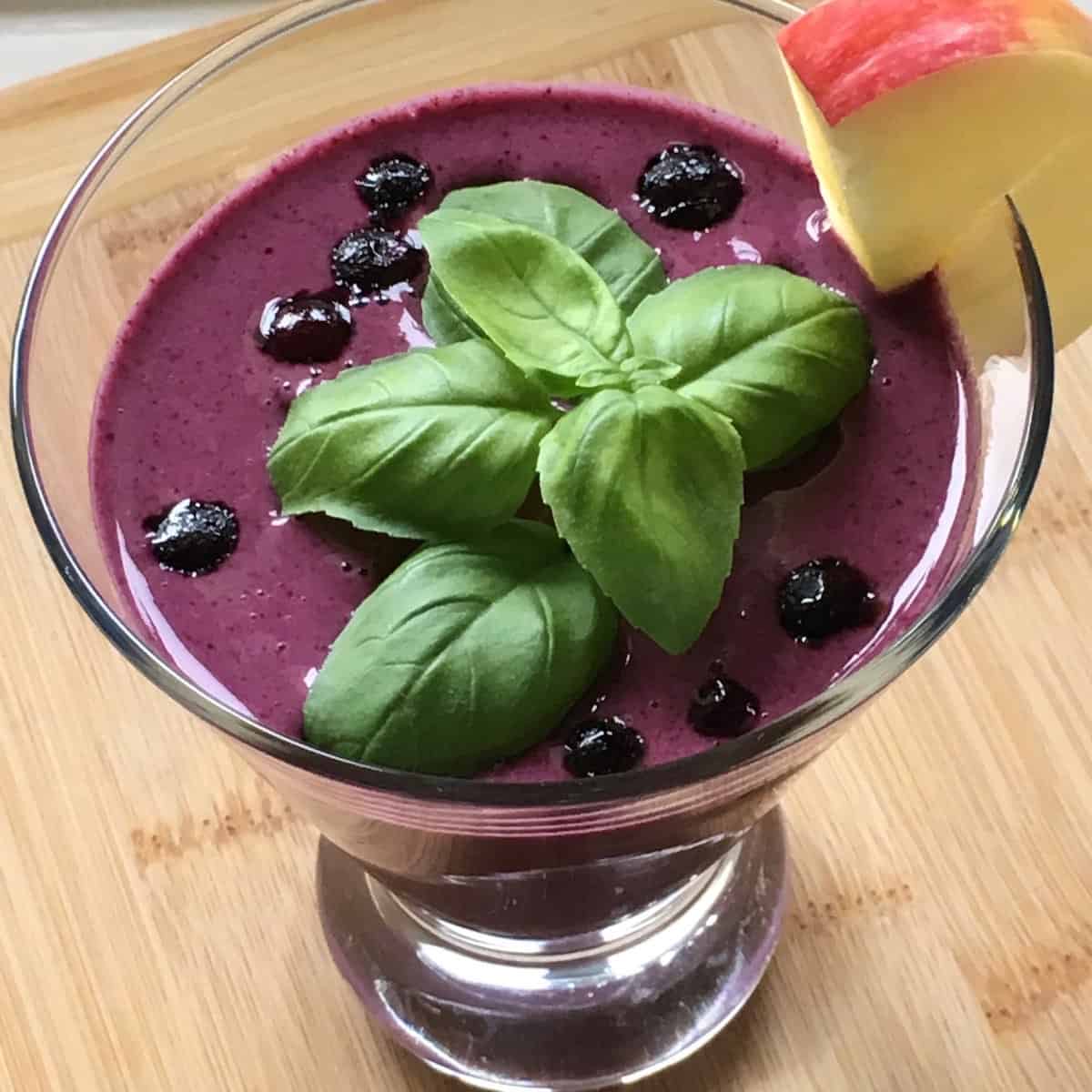 wild blueberry smoothie garnished with basil and apple