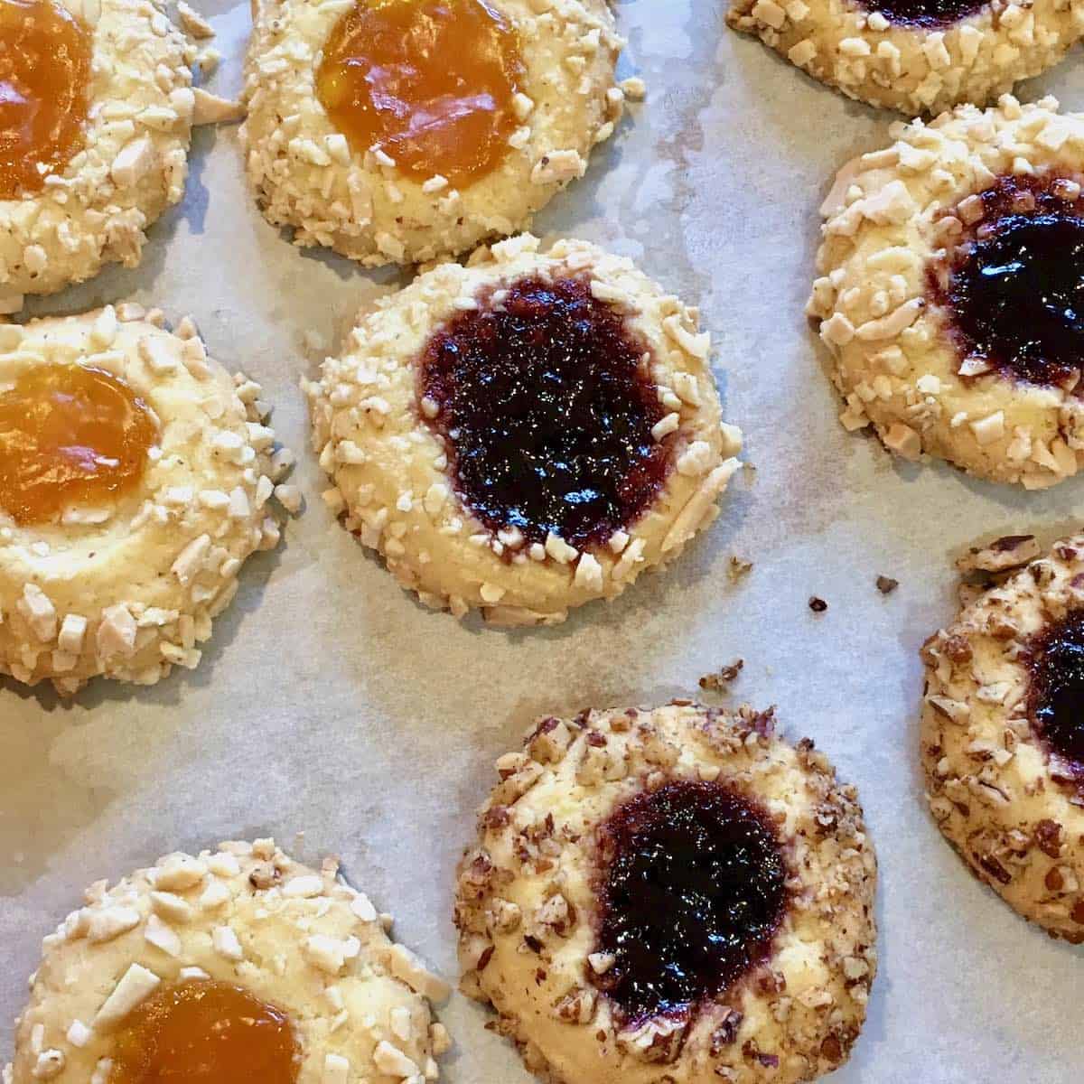 thumbprint jelly cookies on parchment paper