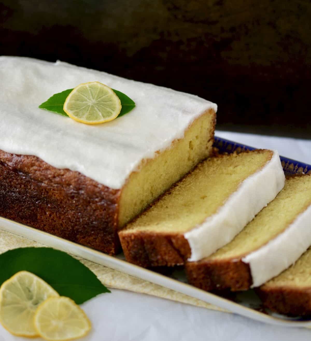 sliced lemon loaf with white icing and lemon slice garnish