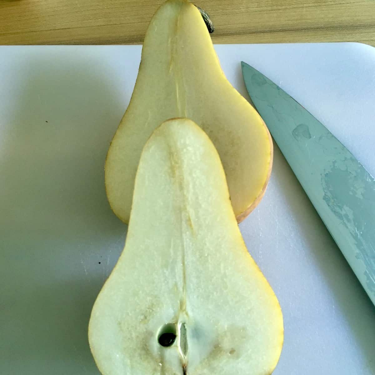 sliced pear with knife on cutting board prepping for salted chocolate pear pound cake